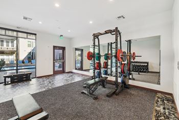 a gym with weights and dumbbells in the corner of a room at Link Apartments® Broad Ave, Tennessee
